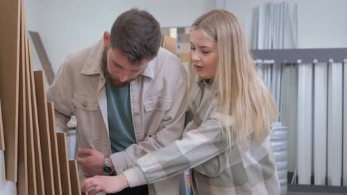 A Young Family is Looking at Exhibition Samples of Laminate in a Building Materials Supermarket