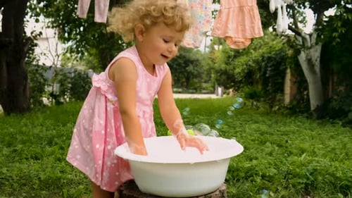 The Child is Washing Clothes in the Garden Selective Focus