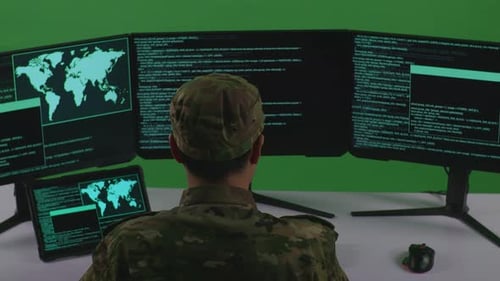 Back View Of Man Soldier Working With Tablet While Write Code With Multiple Screens In Green Screen