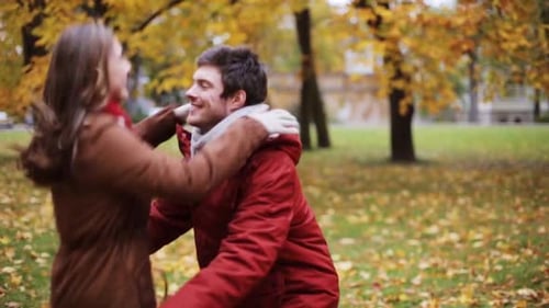 Happy young couple meeting and embracing in a beautiful autumn park montage
