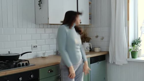 Woman Dancing in Kitchen at Home
