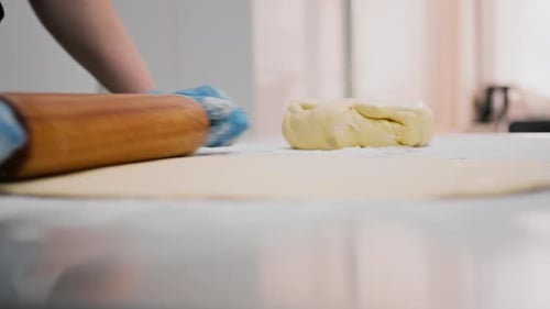 The kitchen in the bakery - the process of preparing cinnabons, the woman baker forms doughs