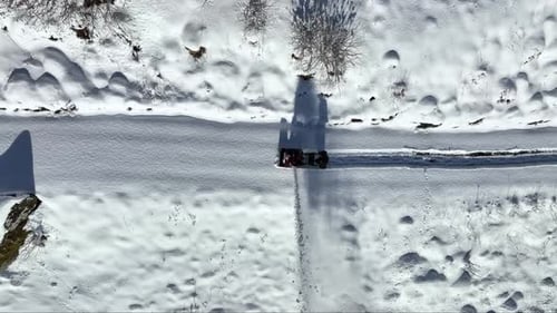 Aerial birdseye view of person clearing road with snow blower in Norway - 60 fps