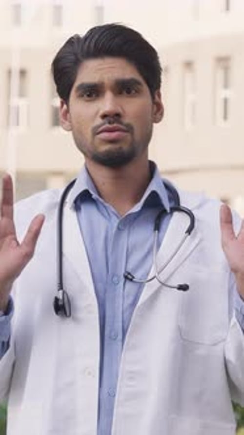 Confident Young Doctor Talking Outside of Clinic