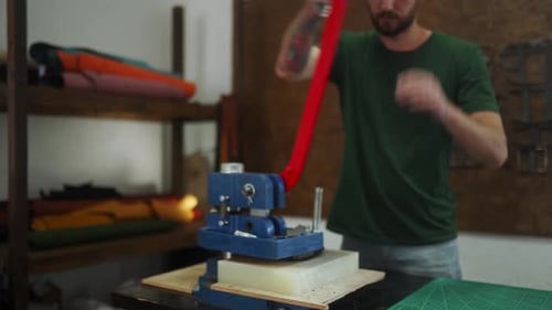 Man Cuts Leather with Die Cut Machine in Workshop