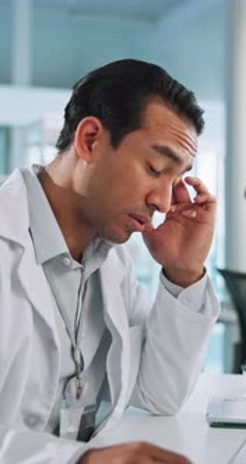 Exhausted Doctor with Headache in Bright Office