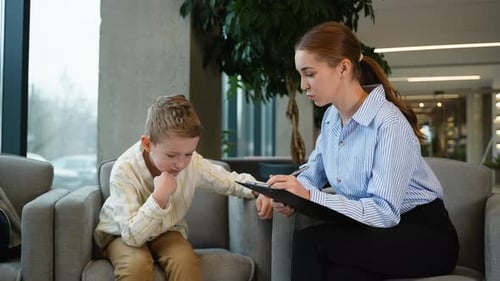 Child Psychologist Counseling a Thoughtful Young Boy