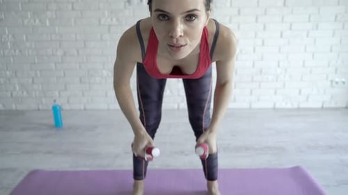 Young Woman Does Bicep Curls with Dumbbells