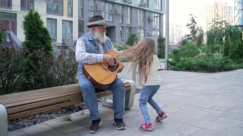 Senior Adult and Child Enjoying Music Outdoors