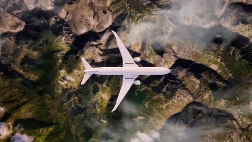 Aerial View of Airplane Flying High Above Rugged Mountain Terrain and Clouds