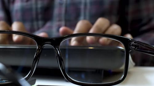 Glasses in Front of Hands Typing at Computer