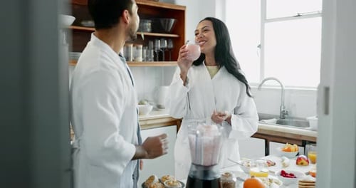 Couple in Robes Making Smoothies in Kitchen