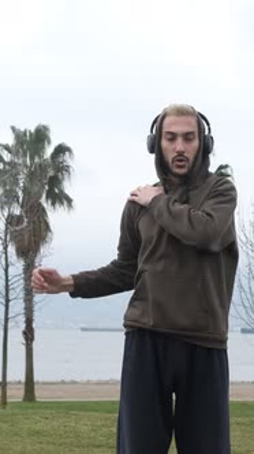 Man Stretching Arms in Urban Park by the Sea
