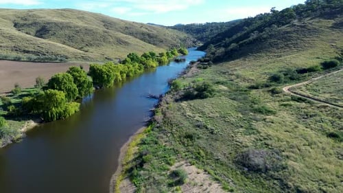 Drone aerial landscape of trees and mountainous valley along Murrumbidgee riverbank embankment water