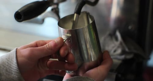Close Up of Man Steaming Milk at Coffee Shop