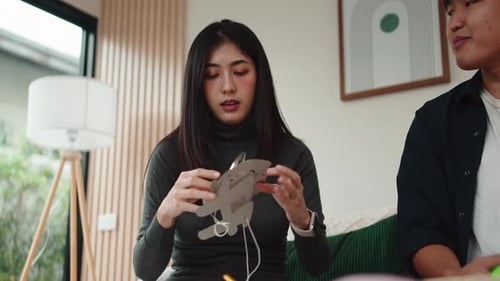 Young Adults Assembling Birthday Decorations Indoors Together