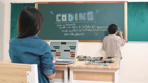 Asian girl writing engineering prompt by using AI software at class. Pedagogy.