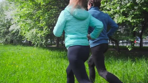 Sportive young people running. Couple run in the city park during the day