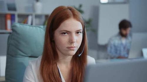 A Woman with Red Hair is Engaged in a Virtual Meeting Showing Remote Work