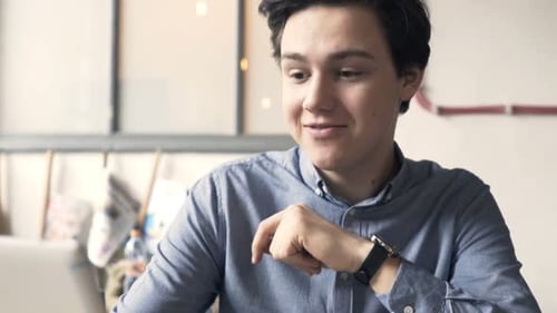 Young Teenager Chatting on Tablet in Cafe Alone