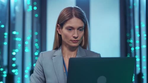 Woman Works on Laptop in Data Center