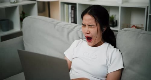 Excited Young Adult Woman with Laptop at Home