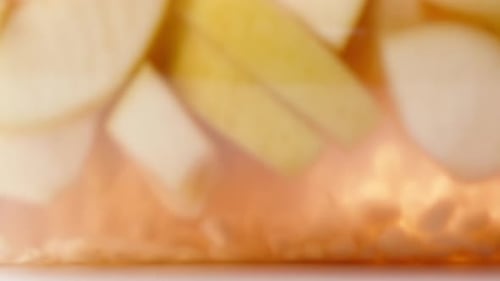 a jar of red juice from apples and pomegranate, rolling on the table, close-up.