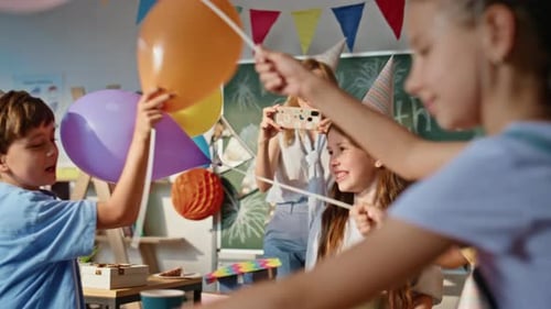 Joyful Children Playing Balloons at Birthday Celebration in School Closeup