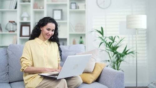 Smiling Woman Works on Laptop at Home