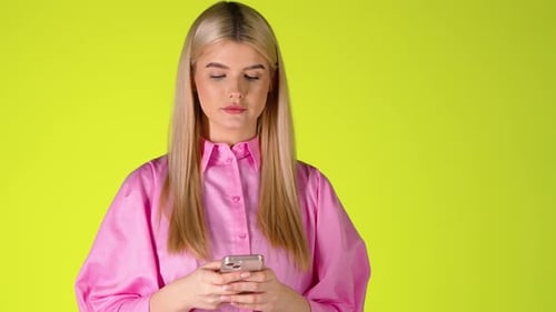 Blonde Woman Holding a Smartphone, Browsing Scrolling The Touch Screen, Studio Shot