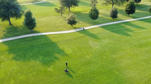 A Man Hits the Ball on the Golf Course Golf Course From Above Player on the Course and Worker Aerial