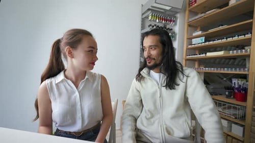 Un homme parle à une assistante pour lui demander d'apporter des documents de projet