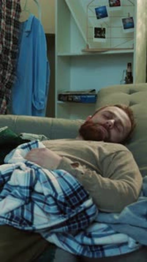 Junge Frau weckt betrunkenen Ehemann, Alkoholiker, der auf dem Sofa liegt, Stress zu Hause, ungesund, gruselig, verzweifelt
