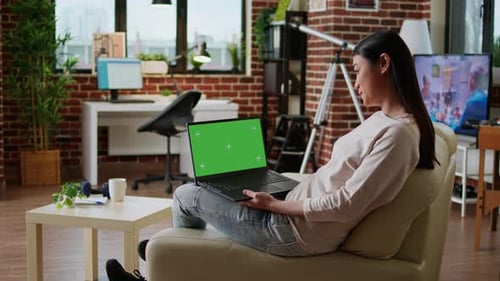Smiling Heartily Asian Woman Using Laptop Having Green Screen Mockup Template Display