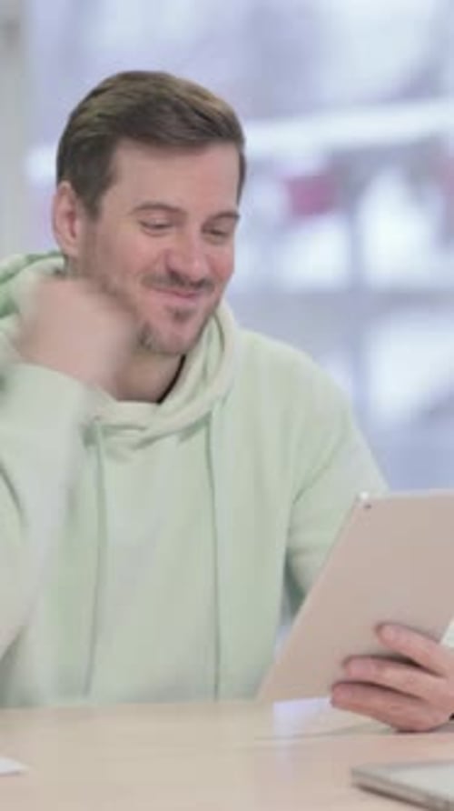 Cheerful Man Using a Tablet Device at Home