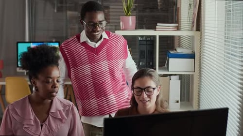 Office Workers Collaborating at Computer in Modern Workplace