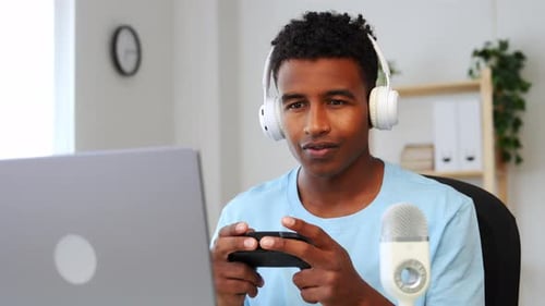 Young Adult Playing Video Game Using Gamepad Controller