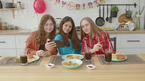 Carefree Adorable Adolescent Female Friends Taking Selfie During Birthday Party