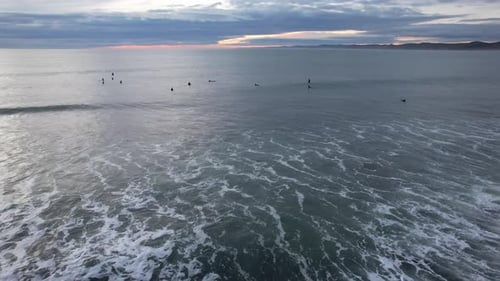 Surfers At Manu Bay During Sunset Near Raglan In Waikato, North Island, New Zealand. Aerial Drone Sh