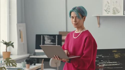 Portrait d'un programmeur asiatique aux cheveux bleus avec ordinateur portable