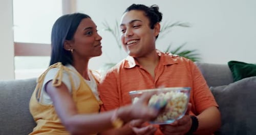 Couple Enjoys Popcorn and TV on Gray Couch