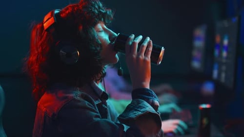 Biracial Female Player Enjoying Energy Drink at Cyberclub