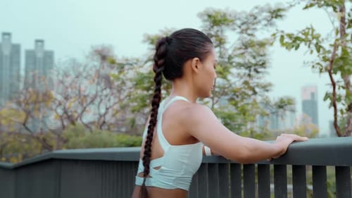 Young fitness woman in sportswear exercising in city park
