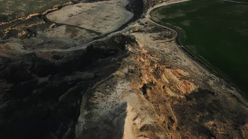 Aerial View of Yellow Desert Mountains Surrounded with Green Fields