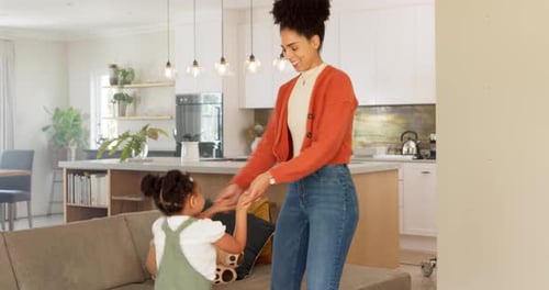 Mother and daughter dancing, celebration and doing fun dance moving to love song in apartment