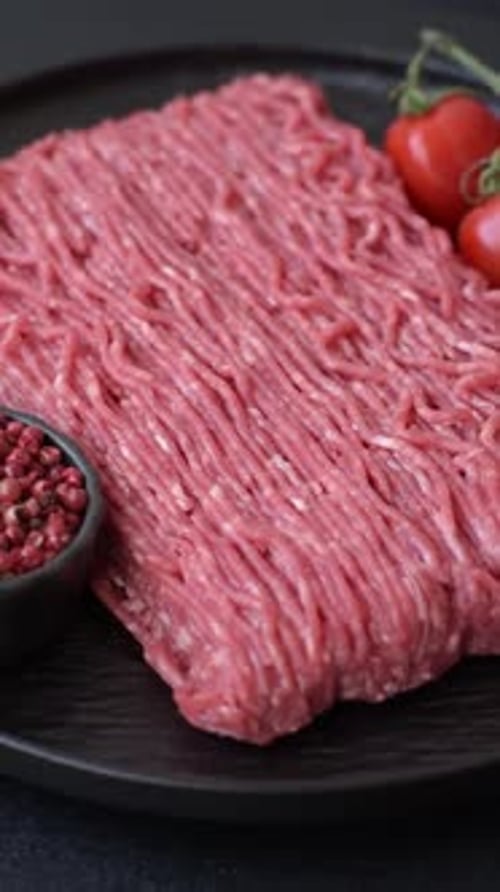 Raw ground beef or pork for burgers or meatballs with salt and spices. Raw ground beef