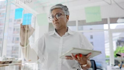 Business woman, brainstorming and tablet notes of agenda, research and schedule on office window