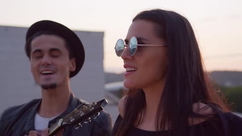 Paar genießt Musik im Freien bei Sonnenuntergang