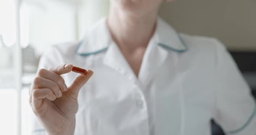 Closeup View of Caucasian Woman Doctor or Nurse Holding Medical Capsule in Her Hand