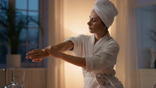 Woman Applies Lotion to Skin After Bath